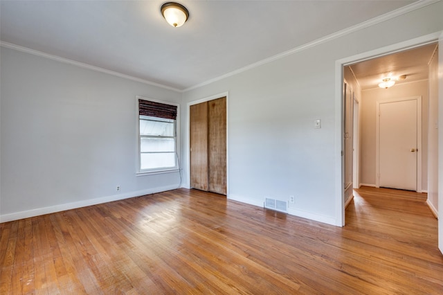 unfurnished room with crown molding and light wood-type flooring