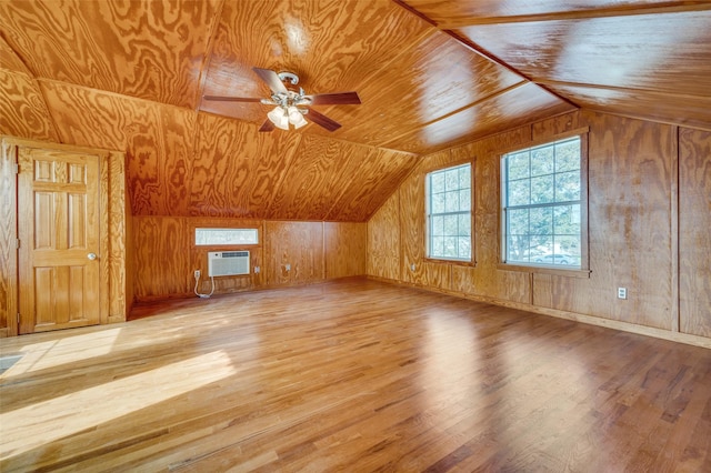 bonus room featuring lofted ceiling, a wall mounted air conditioner, wooden walls, and light hardwood / wood-style flooring