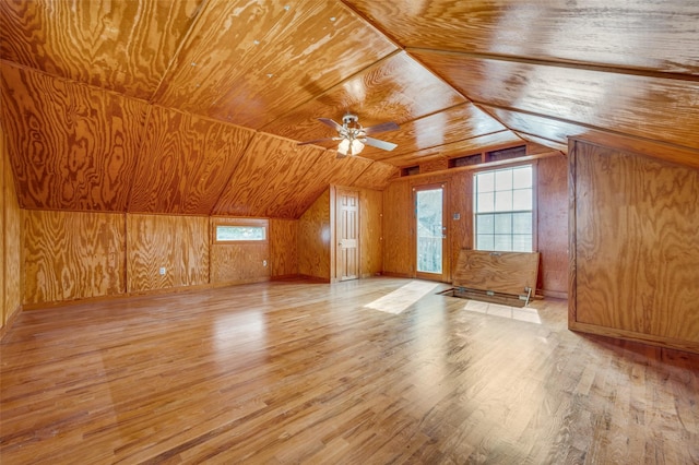 bonus room featuring lofted ceiling, light hardwood / wood-style floors, wooden ceiling, and wood walls