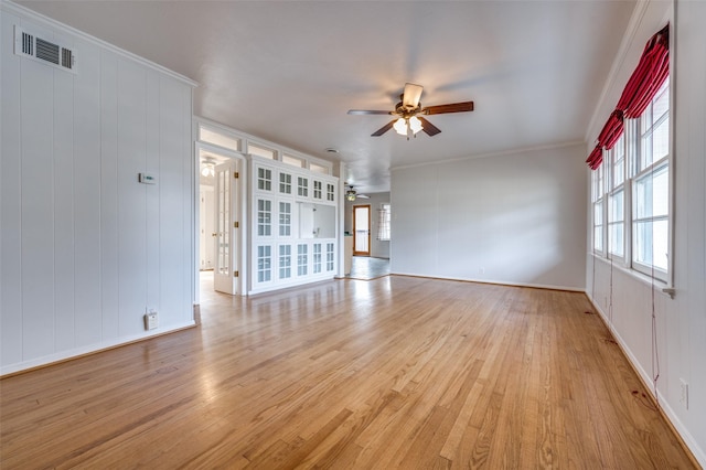 unfurnished living room featuring ceiling fan, ornamental molding, and light hardwood / wood-style flooring