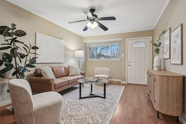 living room featuring hardwood / wood-style flooring, ornamental molding, and ceiling fan