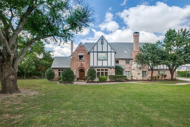 english style home with a front lawn