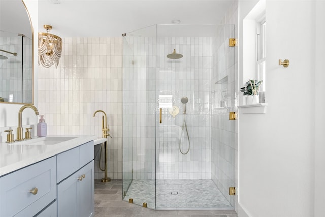 bathroom featuring a shower with door and vanity