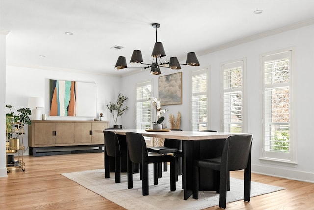 dining space featuring ornamental molding, a fireplace, ceiling fan with notable chandelier, and light hardwood / wood-style flooring