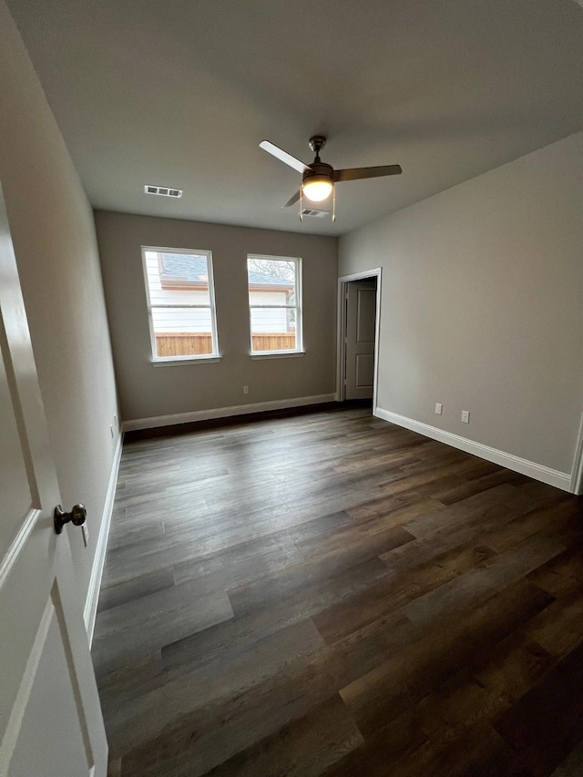 spare room with dark hardwood / wood-style floors and ceiling fan