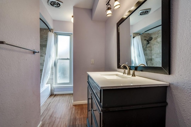 bathroom with vanity, hardwood / wood-style floors, and shower / bath combo with shower curtain