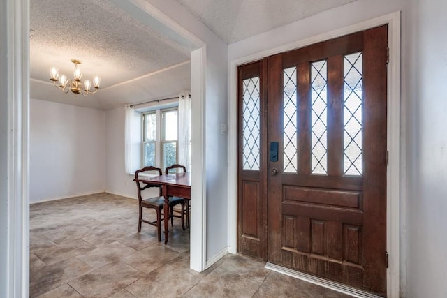 foyer featuring a textured ceiling and a chandelier