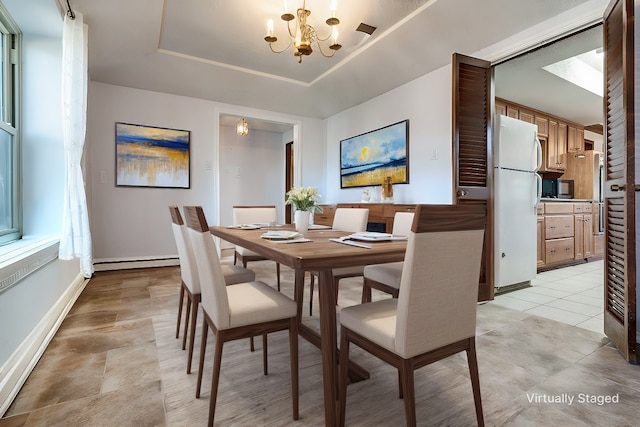 tiled dining space with a baseboard heating unit, a raised ceiling, and a notable chandelier