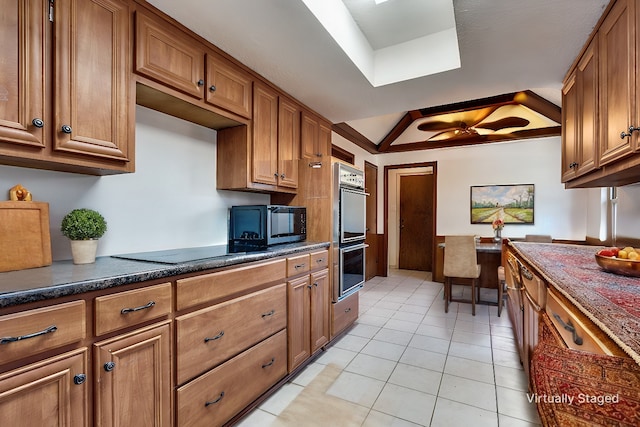 kitchen featuring black electric cooktop, stainless steel double oven, a tray ceiling, and light tile patterned floors