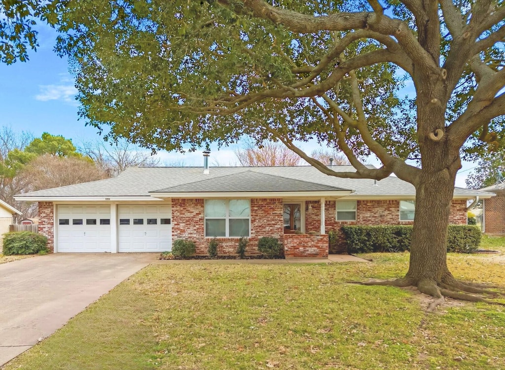 ranch-style home featuring a garage and a front lawn