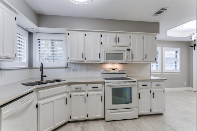 kitchen featuring white cabinetry, white appliances, and sink