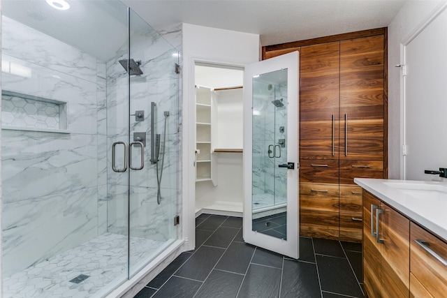 bathroom with tile patterned floors, vanity, and a shower with door