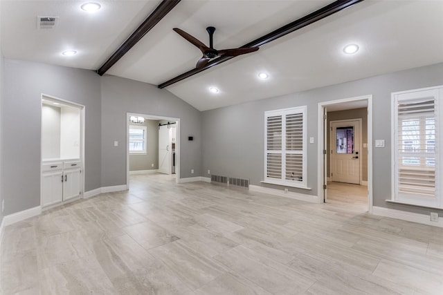 interior space featuring ceiling fan, plenty of natural light, a barn door, and vaulted ceiling with beams