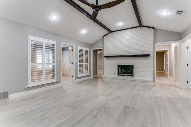 unfurnished living room with lofted ceiling with beams, ceiling fan, and a fireplace