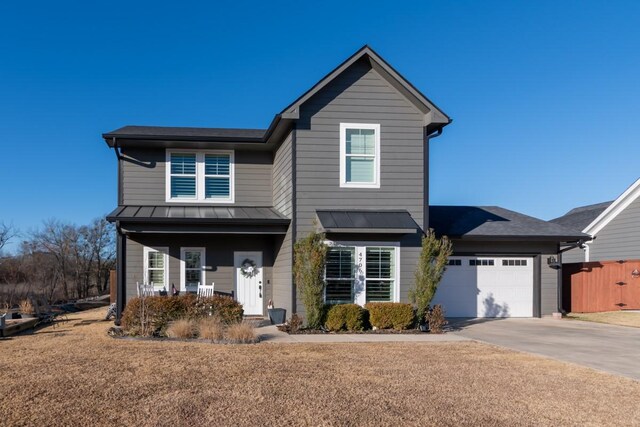 view of front facade with a garage, covered porch, and a front yard