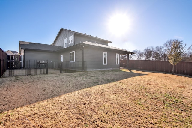 rear view of property featuring a lawn