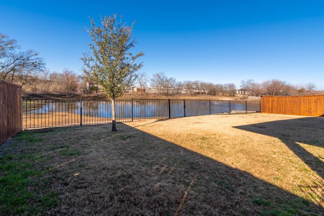 view of yard featuring a fenced backyard and a water view