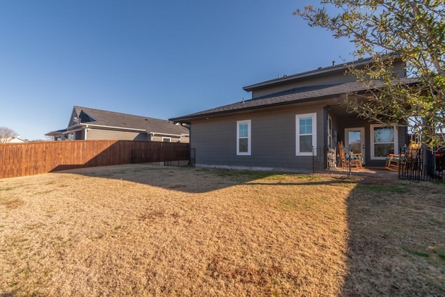 back of house with a patio, fence, and a lawn