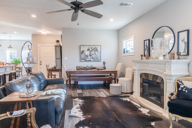 living area with wood finished floors, plenty of natural light, a fireplace, and visible vents