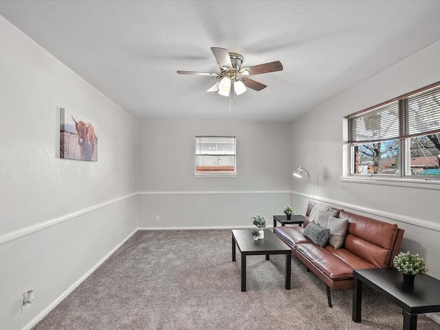 living area featuring ceiling fan and carpet