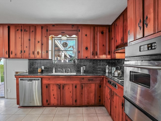 kitchen with light tile patterned flooring, appliances with stainless steel finishes, sink, and backsplash