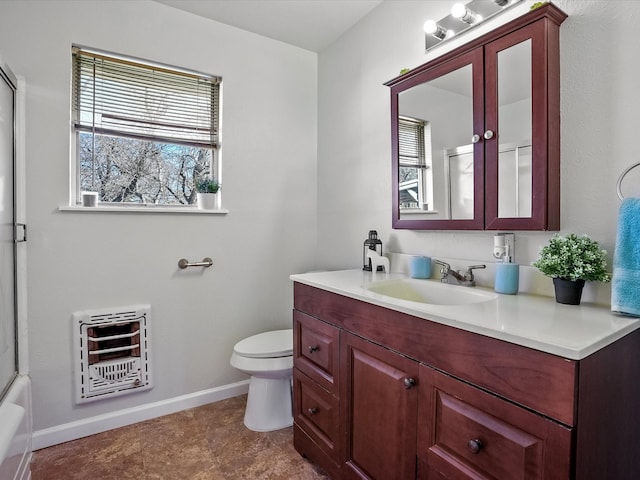 full bathroom with bath / shower combo with glass door, vanity, toilet, and heating unit