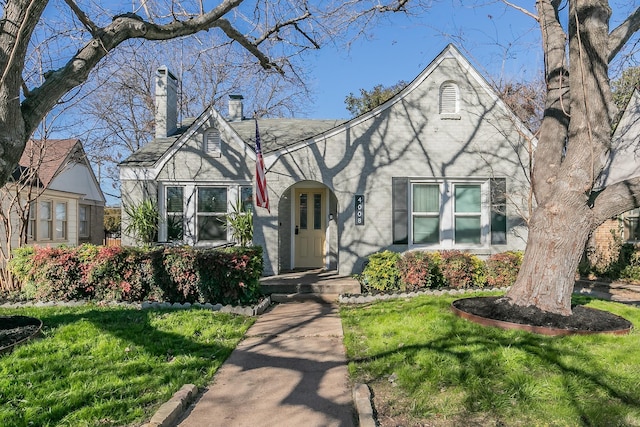 english style home featuring a front lawn