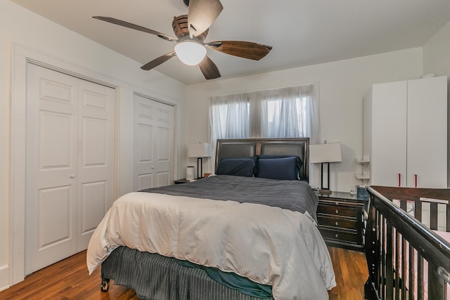 bedroom featuring hardwood / wood-style floors, two closets, and ceiling fan