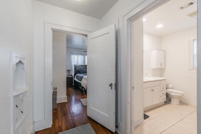 bathroom featuring vanity, wood-type flooring, and toilet