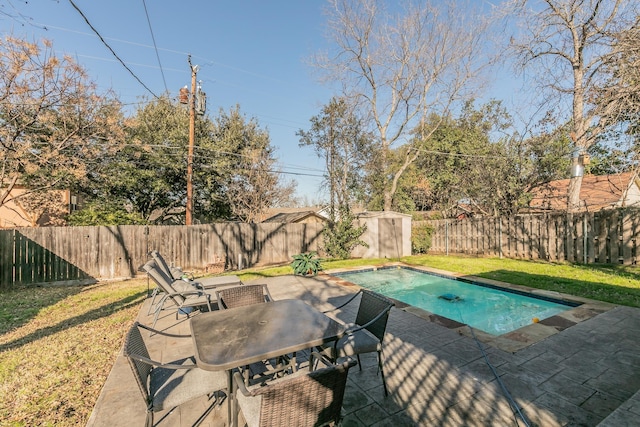 view of swimming pool with a patio, a shed, and a lawn