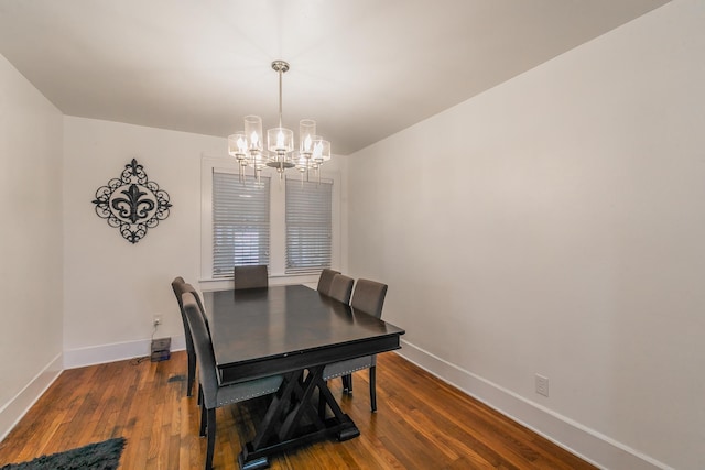 dining area with hardwood / wood-style floors and a notable chandelier