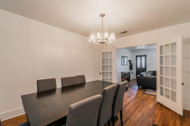 dining area with french doors, dark hardwood / wood-style flooring, and a notable chandelier