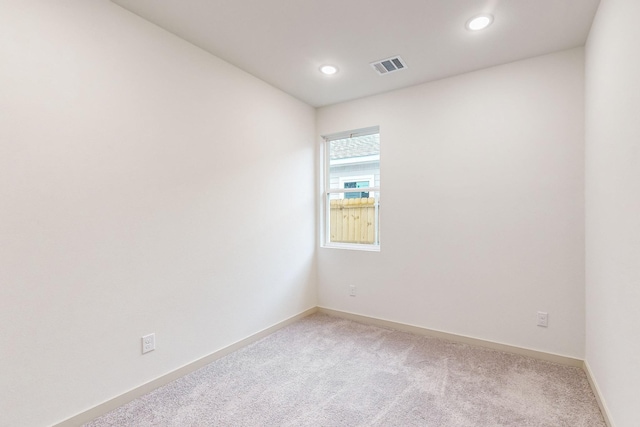 empty room featuring baseboards, recessed lighting, visible vents, and light colored carpet