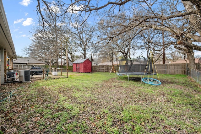 view of yard featuring a storage shed, a trampoline, and central air condition unit