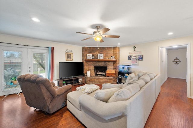 living room with ornamental molding, french doors, a brick fireplace, and wood finished floors