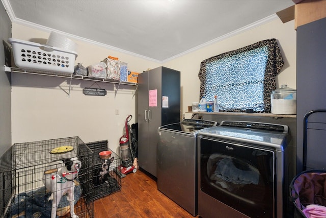 laundry area featuring dark hardwood / wood-style flooring, ornamental molding, and washer and dryer