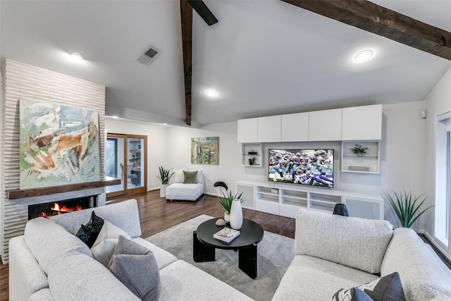 living room with light hardwood / wood-style floors and vaulted ceiling with beams