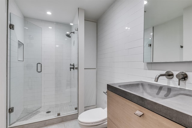 bathroom featuring tile walls, tile patterned flooring, vanity, an enclosed shower, and toilet