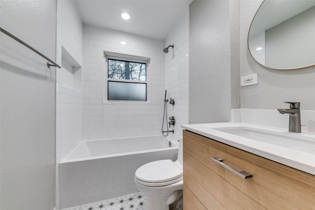 full bathroom with vanity, tiled shower / bath, and toilet