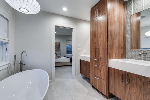 bathroom with vanity, a tub to relax in, tile patterned flooring, and tasteful backsplash