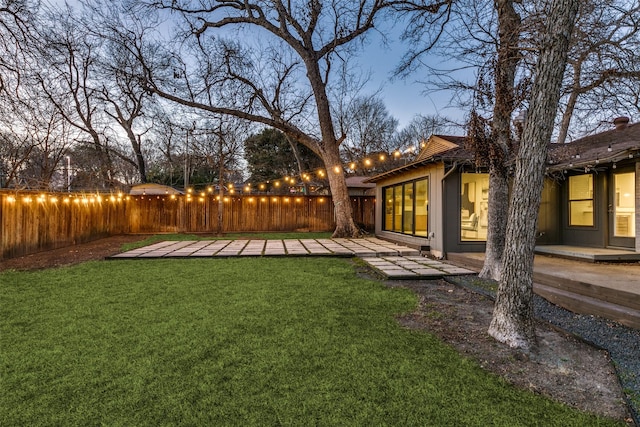 yard at dusk featuring a patio area