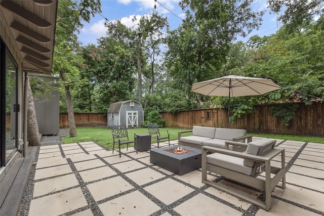 view of patio / terrace featuring a storage shed and an outdoor living space with a fire pit