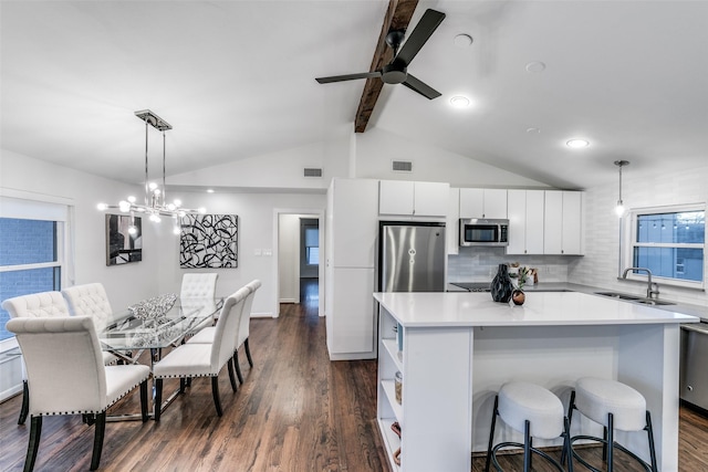 kitchen with sink, a center island, fridge, pendant lighting, and white cabinets