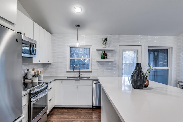 kitchen with pendant lighting, sink, white cabinets, and appliances with stainless steel finishes