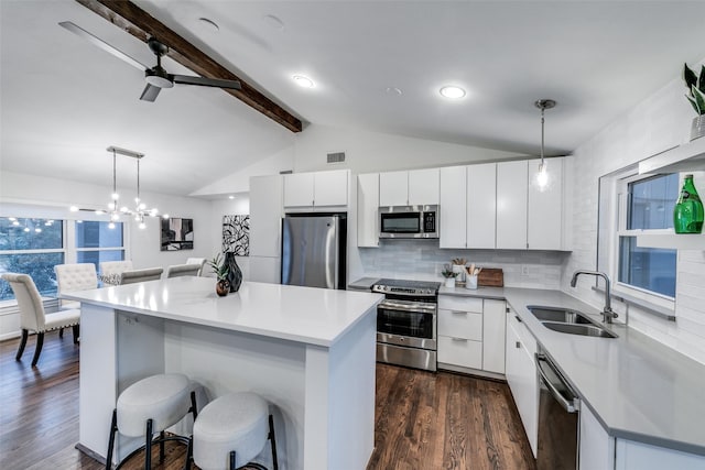 kitchen with pendant lighting, sink, stainless steel appliances, and a center island