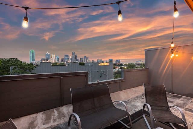 patio terrace at dusk featuring a balcony