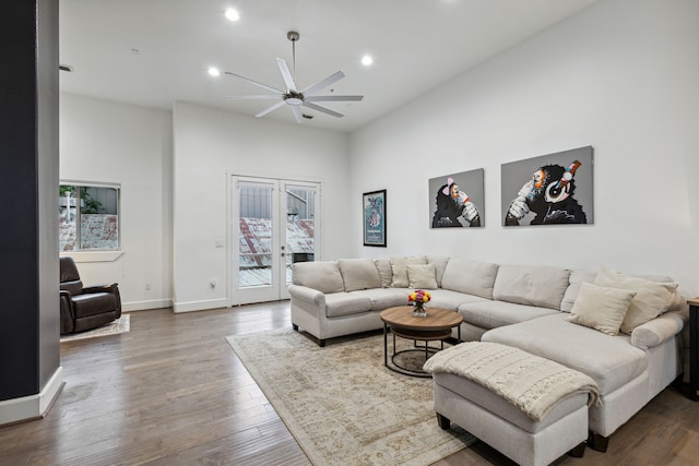 living room with hardwood / wood-style floors, french doors, ceiling fan, and a high ceiling