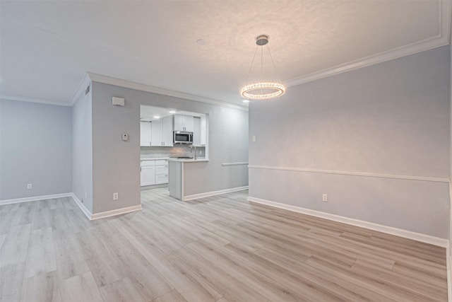 unfurnished living room featuring ornamental molding and light hardwood / wood-style floors