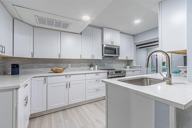 6004 E University Blvd Unit 131, Dallas, TX 75206 - kitchen featuring visible vents, light stone countertops, a sink, appliances with stainless steel finishes, and backsplash
