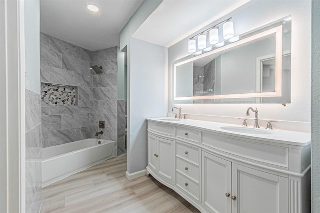 bathroom featuring vanity, wood-type flooring, and tiled shower / bath